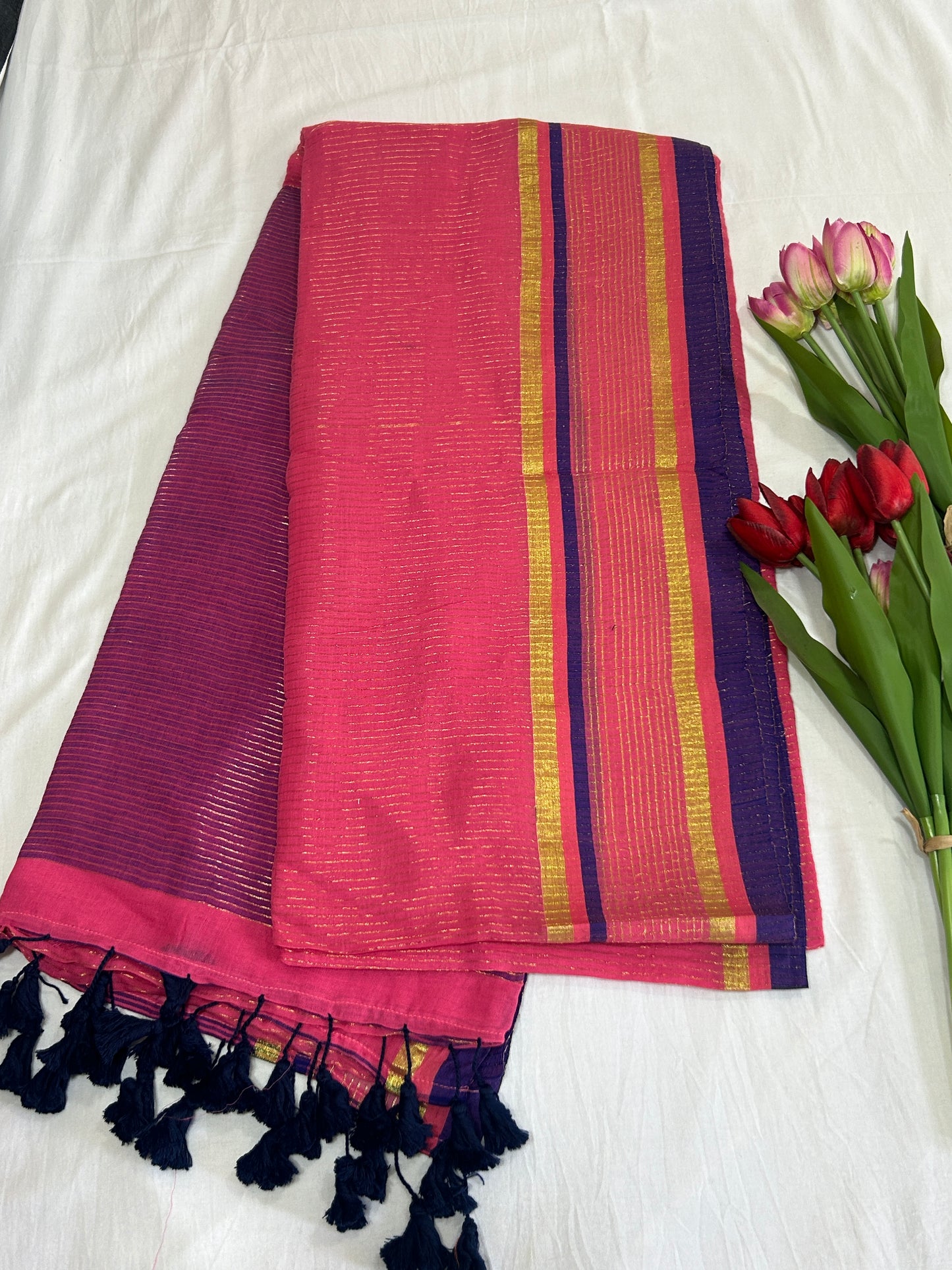 Pink color mulcotton saree with golden lines all over the body and blue and golden striped border SMC235